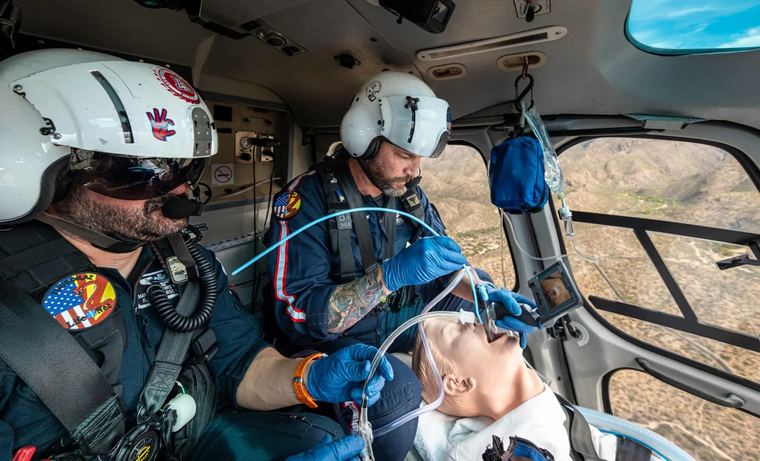 A flight crew manages a patient's airway aboard a medical helicopter