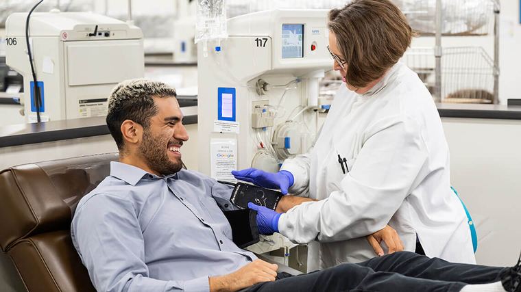 A clinician tends to a donor in a plasma donation center